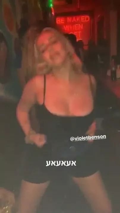 Violet Benson dancing in club in a sexy black dress.